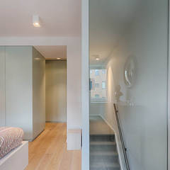 moderne master bedroom met glazenwand t.b.v. mooi lichtopbrengst in trappenhuis:  Slaapkamer door StrandNL architectuur en interieur