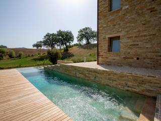 REALIZZAZIONE PISCINE CASTIGLIONE: IN UN CASALE NELLE COLLINE MARCHIGIANE, EDIFICIO, PISCINA E NATURA SI FONDONO IN UN TUTT’UNO PROGETTUALE DI GRANDE PREGIO, PISCINE CASTIGLIONE PISCINE CASTIGLIONE Piscinas de estilo rústico Piscinas