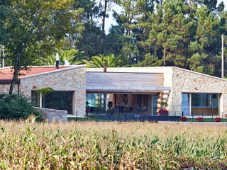 Una Casa con Paredes de Piedra y Jardines de Sueño, HUGA ARQUITECTOS HUGA ARQUITECTOS منازل