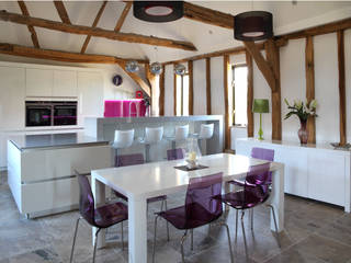 Sleek handle-less kitchen with pink splash-back ensures a modern contemporary look in this barn conversion., John Ladbury and Company John Ladbury and Company Nhà bếp phong cách hiện đại