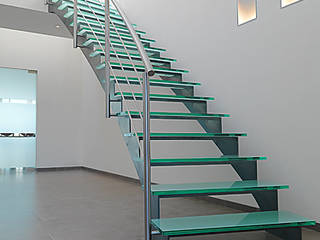 Gebogen trap uit natuurlijk blauw staal met glazen treden, YBIS YBIS Escaleras
