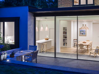 Kitchen/ dining room viewed from the garden of this extended family house in North London. Jones Associates Architects Comedores de estilo moderno house extension, house refurbishment, modern extension, contemporary extension, house renovation, rear extension, roof extension, 1930s house, North London house extension, North London house refurbishment, Crouch End house extension, Crouch End house refurbishment, Crouch End house renovation, Crouch End house alterations, Crouch End architect, Muswell Hill house extension, Muswell Hill house refurbishment, Muswell Hill house renovation, Muswell Hill house alterations, Muswell Hill architect, N10 house extension, N10 house refurbishment, N10 house renovation, N10 house alterations, N10 architect, sliding glass doors, modern windows, aluminium windows, zinc roof, lighting, dining terrace, modern kitchen, contemporary kitchen, kitchen island