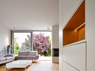 Einbaumöbel mit beleuchteter Nische. Blick in das Wohnzimmer Marcus Hofbauer Architekt Moderne Wohnzimmer