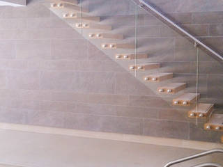 A custom-made floating staircase with oak-clad treads, a clear-glass balustrade and a wall-mounted stainless steel handrail., Railing London Ltd Railing London Ltd Moderne zwembaden