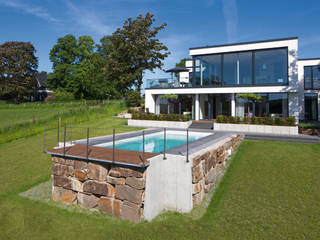 Hanglage - Ein GFK Pool eingebettet in der Natur, Hesselbach GmbH Hesselbach GmbH Jardines de estilo ecléctico Piedra
