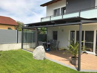 Terrassenverglasung in Anthrazit-Grau mit seitlichen Verglasungen zum schieben als Windschutz, Schmidinger Wintergärten, Fenster & Verglasungen Schmidinger Wintergärten, Fenster & Verglasungen Nhà kính phong cách hiện đại Nhôm / Kẽm