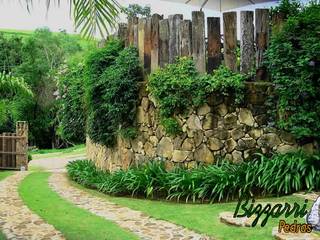 Muro de arrimo com pedras, plantas e dormentes, Bizzarri Pedras Bizzarri Pedras Rustic style garden