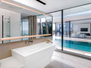 The Jle studio gives importance to content, using KRION and glass in a home in Mallorca, KRION® Porcelanosa Solid Surface KRION® Porcelanosa Solid Surface モダンスタイルの お風呂