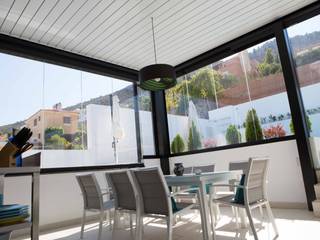 Ático con pérgola bioclimática y cortinas de cristal, Kauma Kauma Balcones y terrazas de estilo moderno