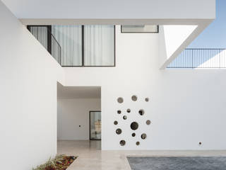 Entrada principal AAP - ASSOCIATED ARCHITECTS PARTNERSHIP Floors Stone Fachada principal, canteiro para vegetação, pedra bege, branco, preto, pedra natural, Mármore Omani, paredes brancas