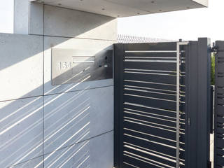 Black Heron. Minimalistyczne ogrodzenie z betonu architektonicznego i aluminium, XCEL Fence XCEL Fence Halaman depan