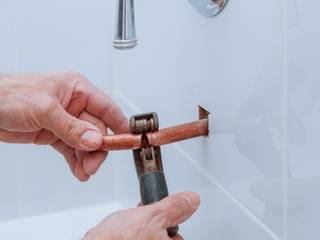 copper pipe cutting in bathroom, Plumbers Network Strand Plumbers Network Strand モダンスタイルの お風呂