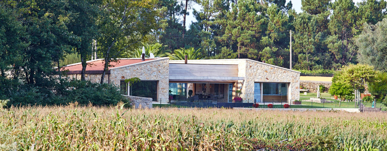 Una Casa con Paredes de Piedra y Jardines de Sueño, HUGA ARQUITECTOS HUGA ARQUITECTOS Rustic style house