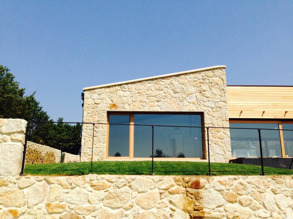 Una Casa con Paredes de Piedra y Jardines de Sueño, HUGA ARQUITECTOS HUGA ARQUITECTOS Будинки