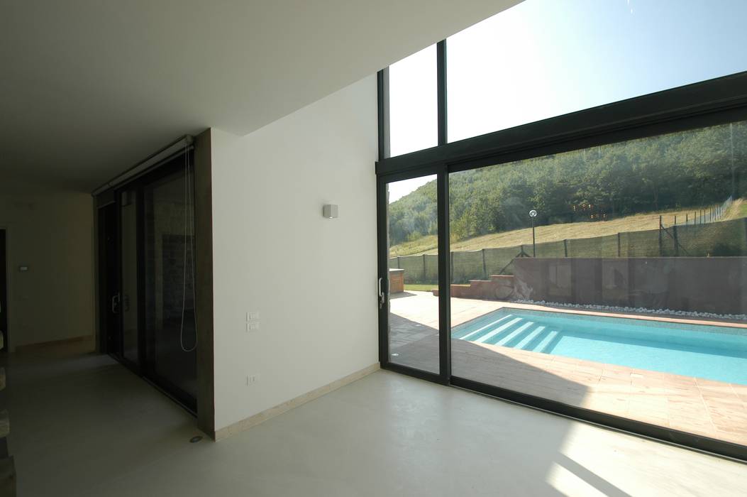 Villa unifamiliare con piscina a Foligno (PG), Fabricamus - Architettura e Ingegneria Fabricamus - Architettura e Ingegneria Soggiorno minimalista living,vetrata,doppia altezza,resina,minimal,stilemoderno,pavimento resina,vetrate,interior design,interior