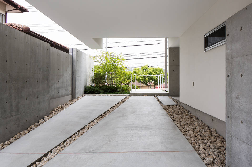 The House supplies a monotonous street with a passing view, Kenji Yanagawa Architect and Associates Kenji Yanagawa Architect and Associates Garagens e arrecadações modernas
