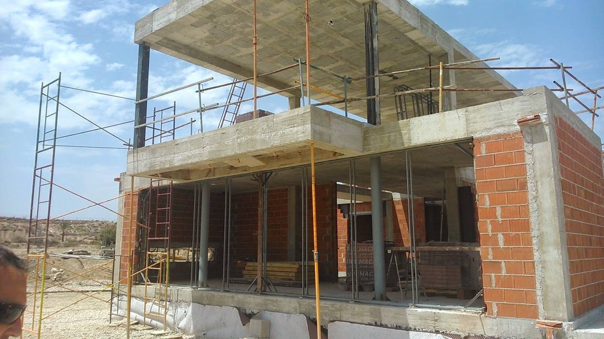 UNA CASA EN H REVESTIDA DE PIEDRA, NUÑO ARQUITECTURA NUÑO ARQUITECTURA Maisons modernes