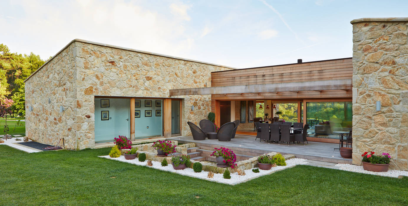 Una Casa con Paredes de Piedra y Jardines de Sueño, HUGA ARQUITECTOS HUGA ARQUITECTOS منازل