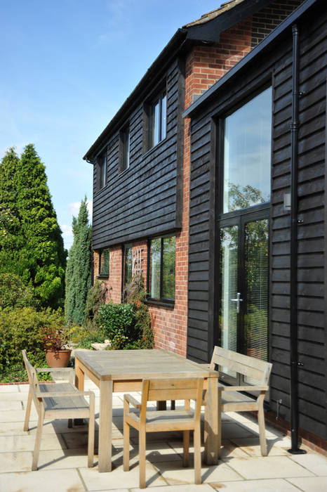 A South-Facing Patio ArchitectureLIVE Case moderne Legno Effetto legno double-height window,house extension,before and after,patio,timber cladding,insulated cladding