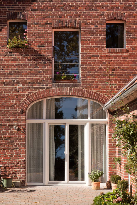 Ehemaliges Scheunentor mit großzügiger Verglasung Lecke Architekten Fenster & Türen im Landhausstil