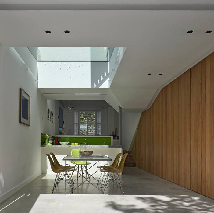 Dining and Kitchen space with folded planes and skylight Neil Dusheiko Architects Modern dining room