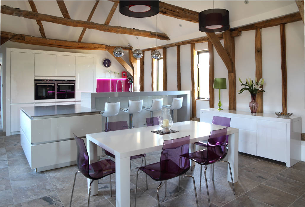 Sleek handle-less kitchen with pink splash-back ensures a modern contemporary look in this barn conversion., John Ladbury and Company John Ladbury and Company Modern kitchen
