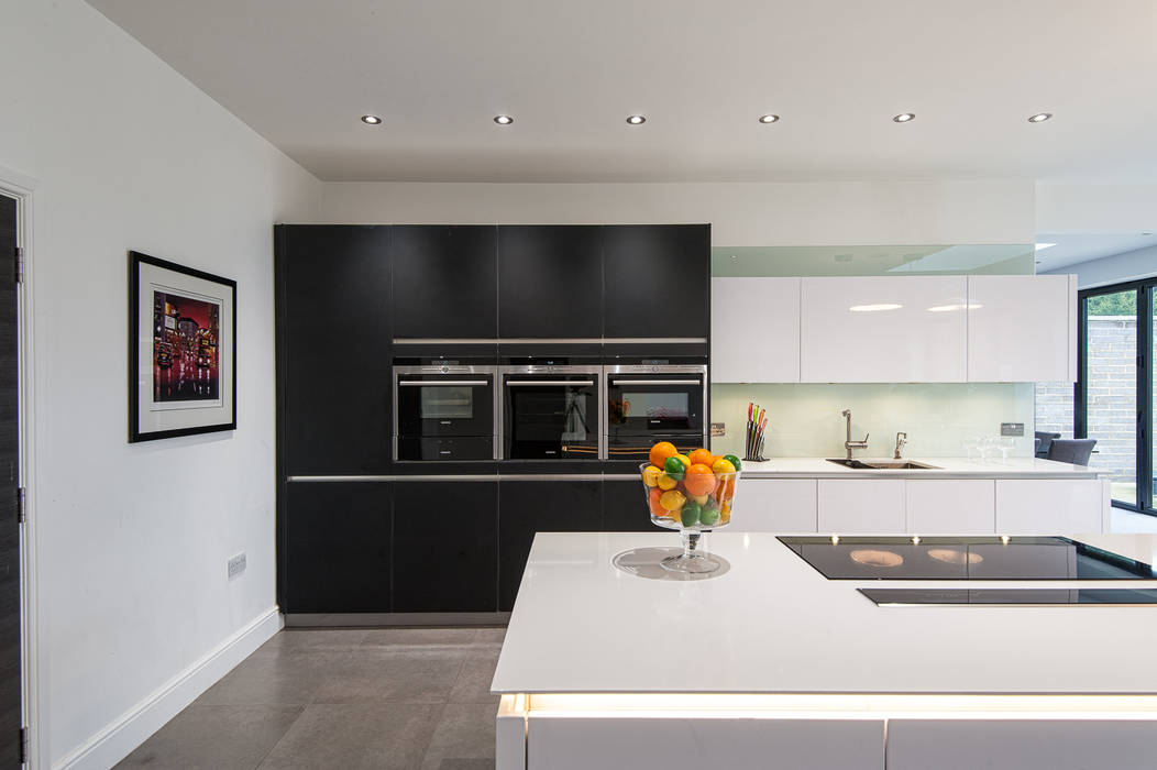 Urban Style Kitchen - White handle-less kitchen with satin black glass units homify Modern kitchen