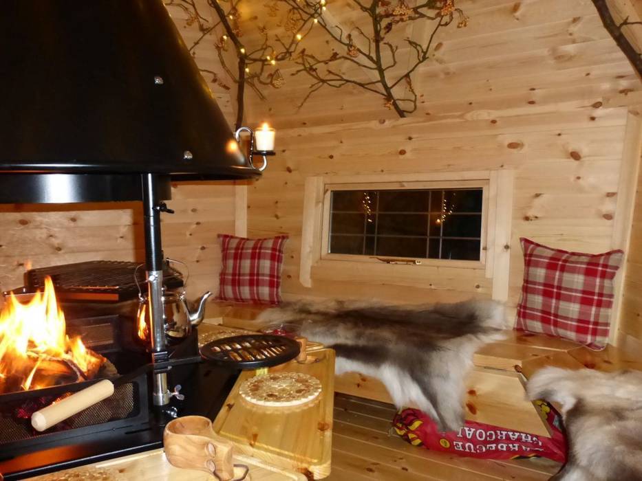 The interior of a 10m² cabin, fire going lovely cushions and reindeer skins on the benches. Arctic Cabins Scandinavian style garden
