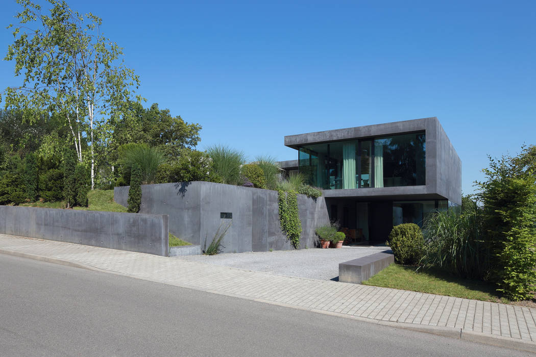 Modernes Einfamilienhaus aus Sichtbeton, Architekturbüro Dongus Architekturbüro Dongus Moderne Häuser Himmel,Pflanze,Baum,Straßenbelag,Grundstück,Asphalt,Urban design,Wohngebiet,Verbundwerkstoff,Landschaft