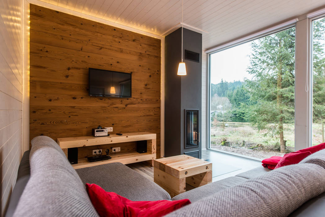 Ein schlanker Kamin und der rustikale Holzspiegel garantieren gemütliche Abende im Kreise Ihrer Lieben Ferienhaus Lichtung im grünen Herzen Deutschland Skandinavische Wohnzimmer