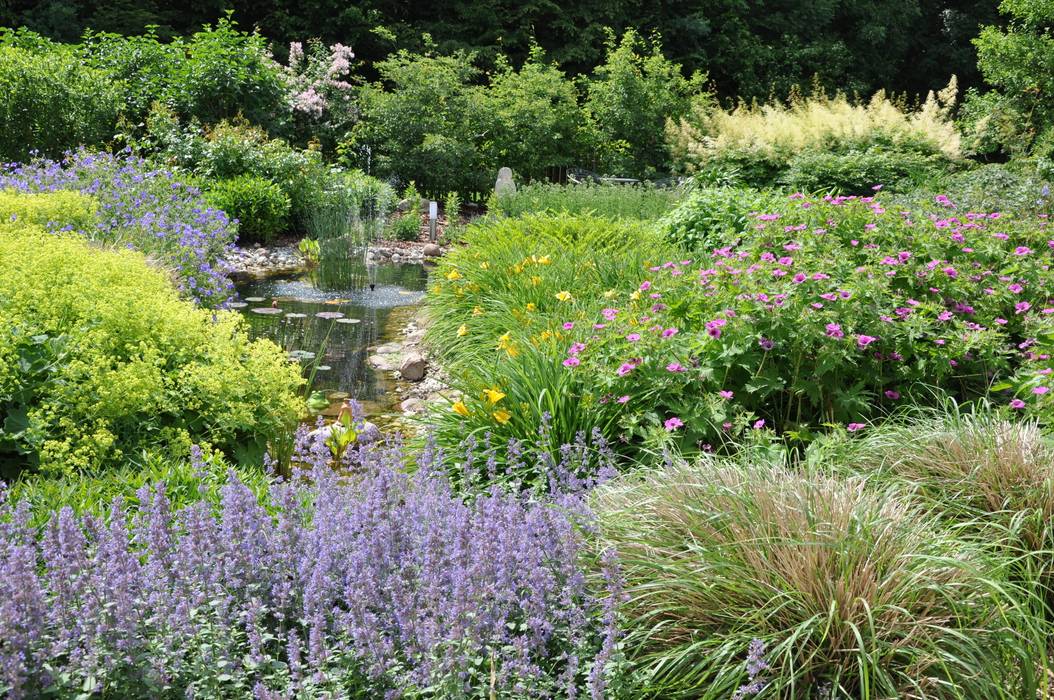 ein kleiner Bach mäandert durch die Staudenbeete Ambiente Gartengestaltung Garten im Landhausstil