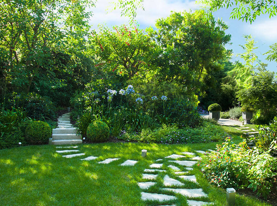 Il prato con vialetti in pietra e aiuole: giardino in ...