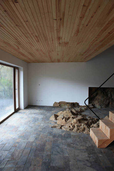 Vista da sala com o afloramento rochoso Atelier do Corvo Salas de estar modernas