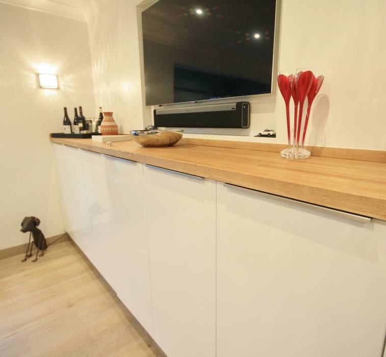 White gloss doors, with silver trim handles Kitchencraft モダンデザインの 多目的室