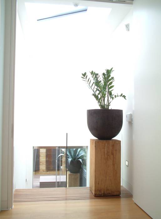 Landing with Oak block and Hand-thrown pot linking to terrace just below through glass doors. Space Alchemy Ltd 現代風玄關、走廊與階梯