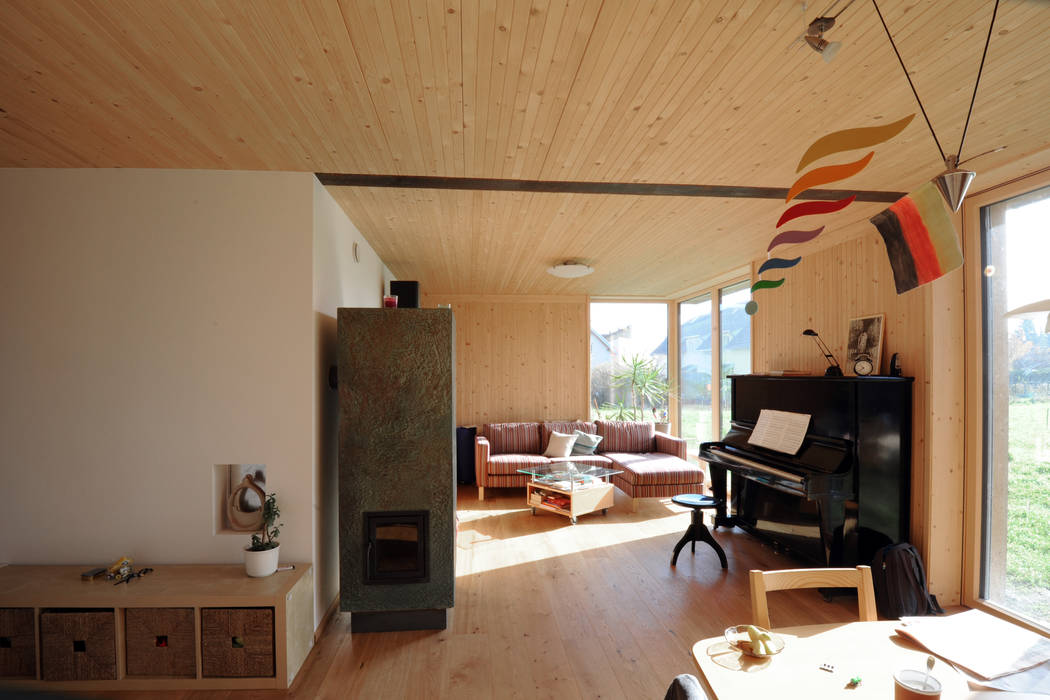 Innenansicht Wohnberich Erdgeschoß bewohnt Symbios Architektur Moderne Wohnzimmer Holz Holznachbildung