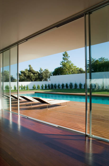 Vista da sala para a piscina A.As, Arquitectos Associados, Lda Salas de estar modernas