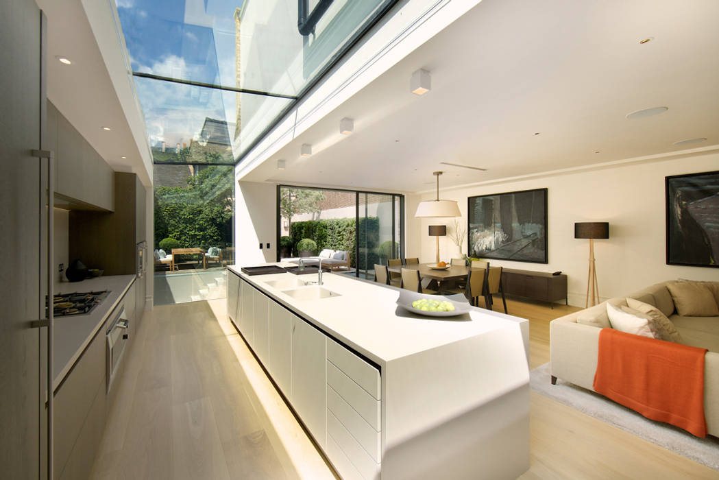 ​Kitchen and sitting area with views of the back garden at Bedford Gardens house. Nash Baker Architects Ltd Cozinhas modernas Vidro