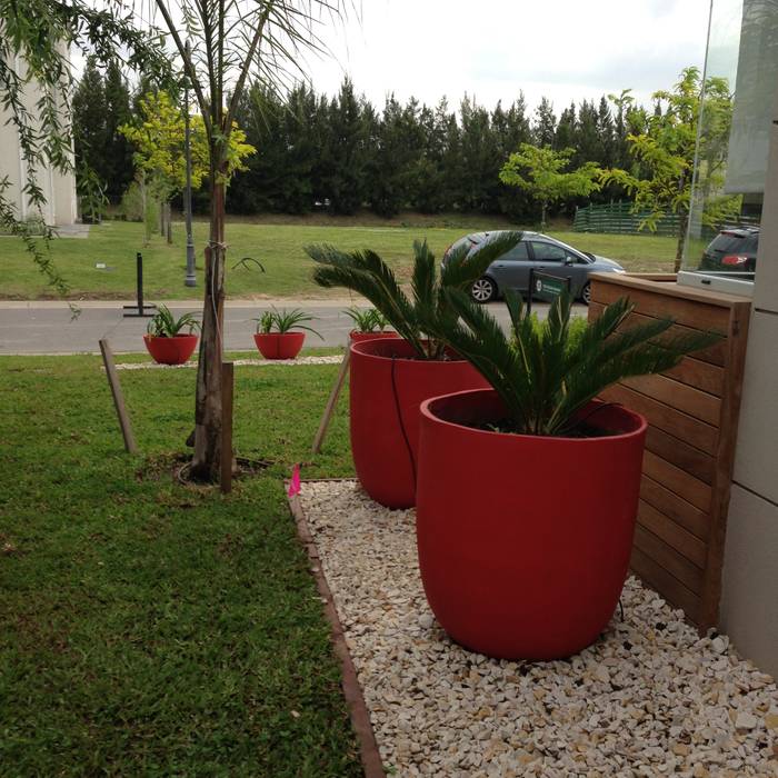 un jardin bien moderno con grandes macetas rojas BAIRES GREEN Jardines modernos: Ideas, imágenes y decoración