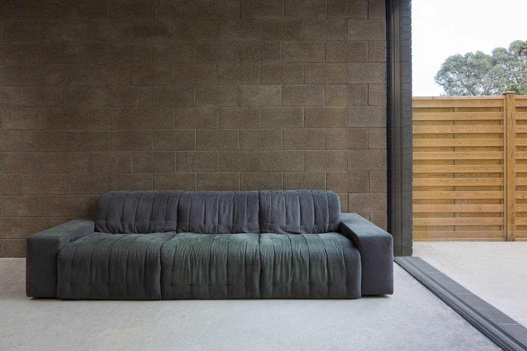 View of exposed block work wall to living area Mustard Architects Industrial style living room