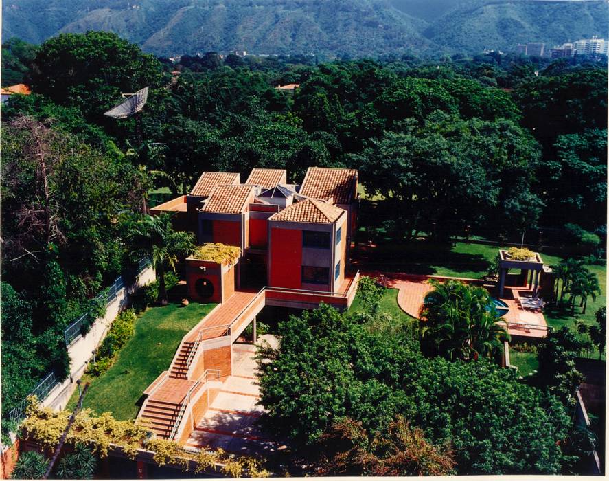 Vista de la casa desde su cara sur, al fondo el campo de golf de la urbanización . OMAR SEIJAS, ARQUITECTO Casas de estilo tropical