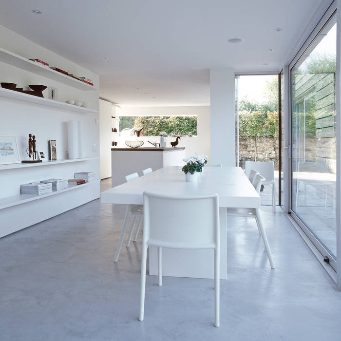 The dining area looking towards the kitchen at ​the Old Hall in Suffolk Nash Baker Architects Ltd Modern Dining Room Concrete