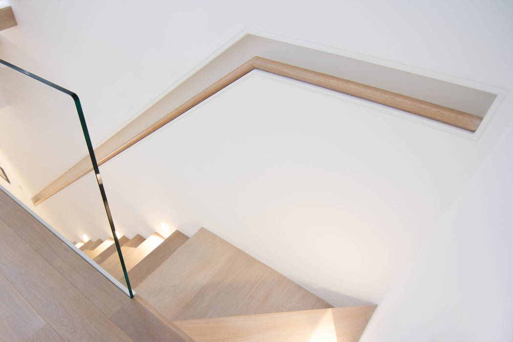 A minimalist floating staircase with oakclad treads and glass wall