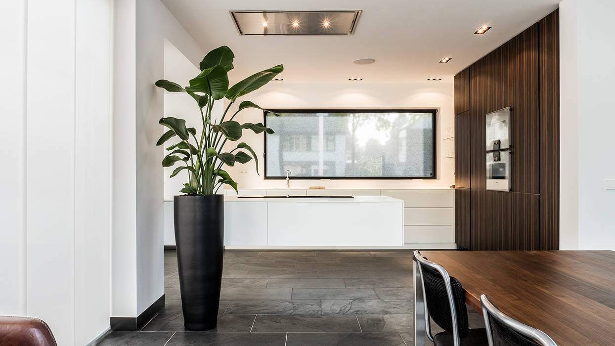 Luxe renovatie met zwevende dakopbouw, maatwerk keuken met zwevend HI-MACS keukenblok en houtfineer kastenwand, van Os Architecten van Os Architecten Kitchen