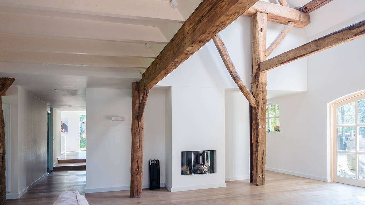 Herindeling woonboerderij met behoud van oude spanten, luxe woonkeuken en open slaapkamer met badkamer in zolder, van Os Architecten van Os Architecten Moderne woonkamers