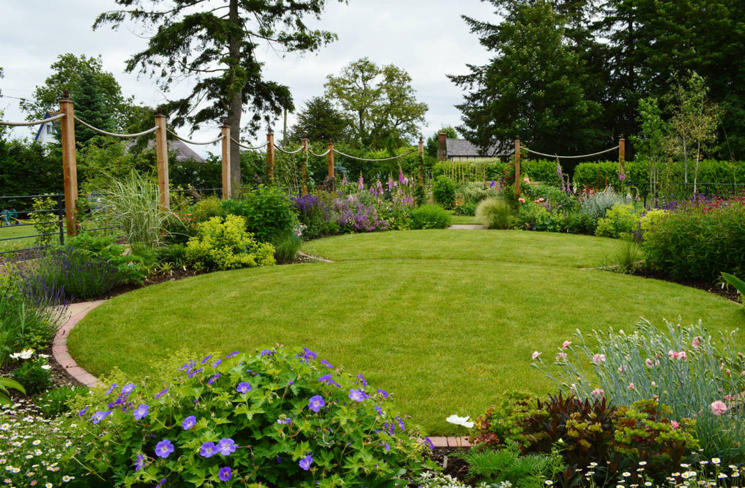 Circular lawns and timber posts support ropes on to which roses and clematis will climb Unique Landscapes Country style garden timber posts,rope,lawn,circular lawn,traditional planting,country garden