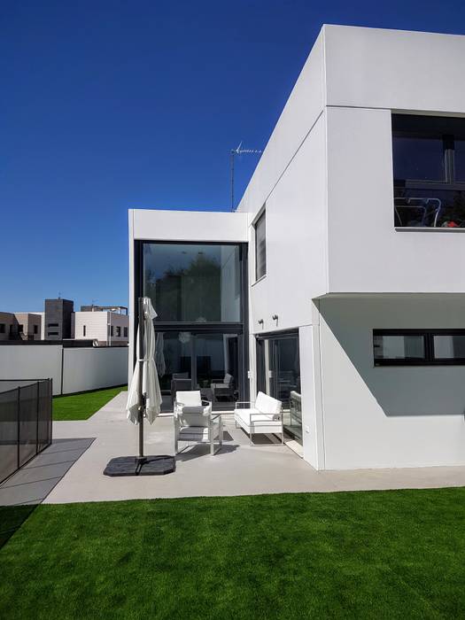 Salón a doble altura vista desde el jardín MODULAR HOME Antejardines Concreto