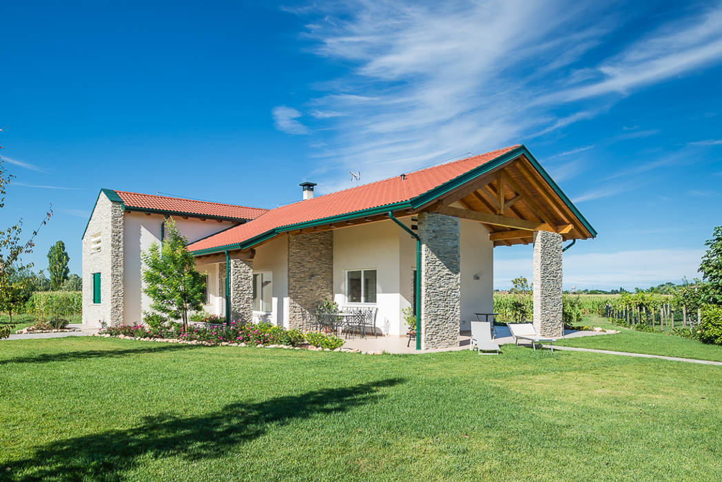 Una villa immersa nel verde Woodbau Srl Casa di legno Legno Effetto legno casa in legno,edifici in legno,legno,xlam,casa al mare,pietra