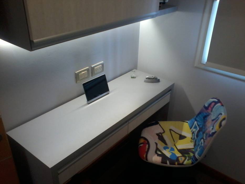 Detalle del sitio escritorio, con mesón U con cajones y alacena para libros con iluminación led, en conjunto con la cama. D&C Interiores Dormitorios infantiles modernos: