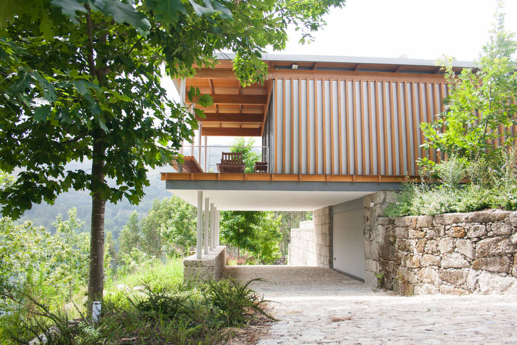 acesso à garagem sob a casa A+ arquitectura Casas modernas Plantar,Sombra,Terreno,Céu,Madeira,Árvore,Cabana,Paisagem natural,Grama,Panorama